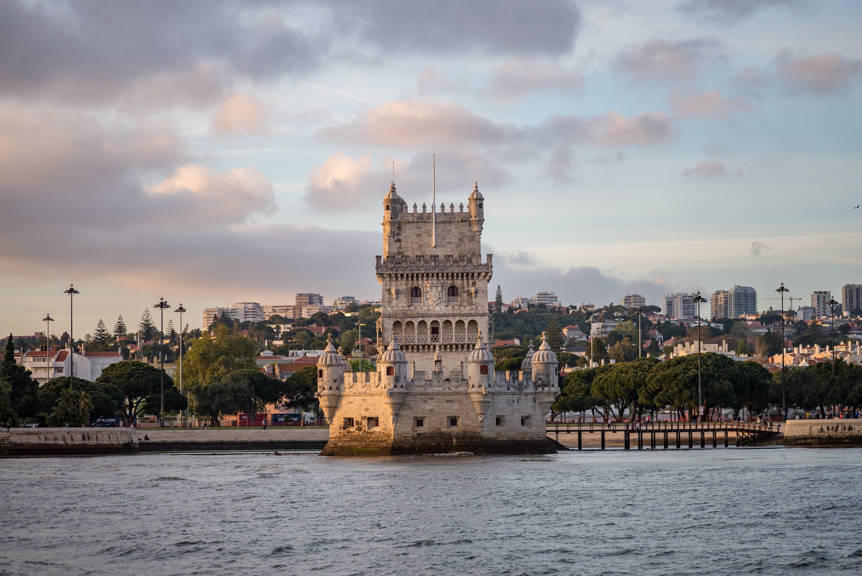 tower-belem-surrounded-by-sea-buildings-cloudy-sky-portugal